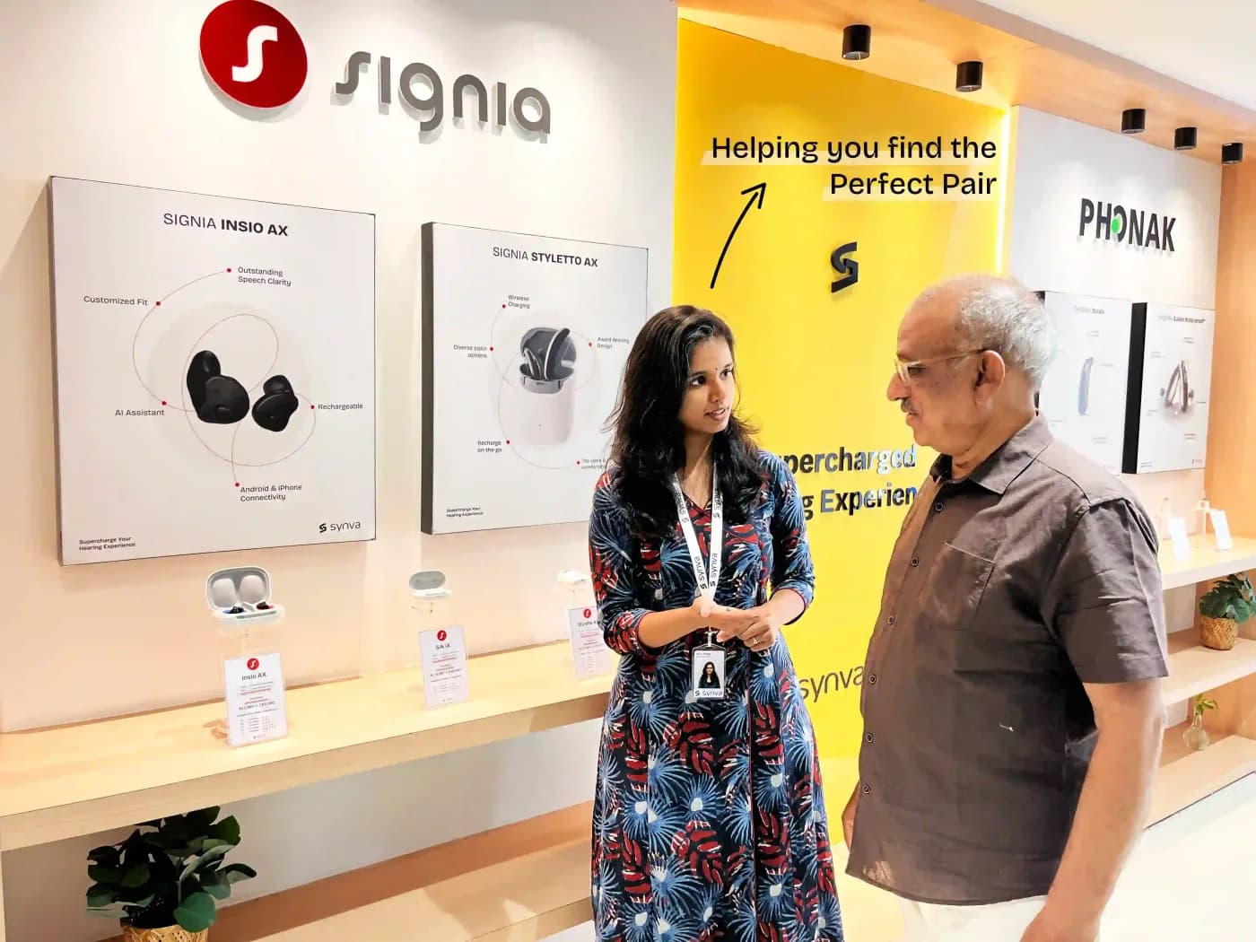Inside the Synva Experience Centre in Hyderabad: the Signia and Phonak display walls, with a Synva audiologist guiding a customer.